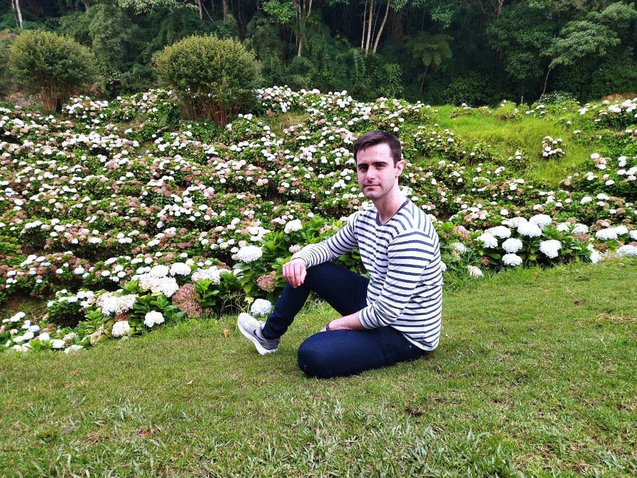 Rolando sitting in a flower garden